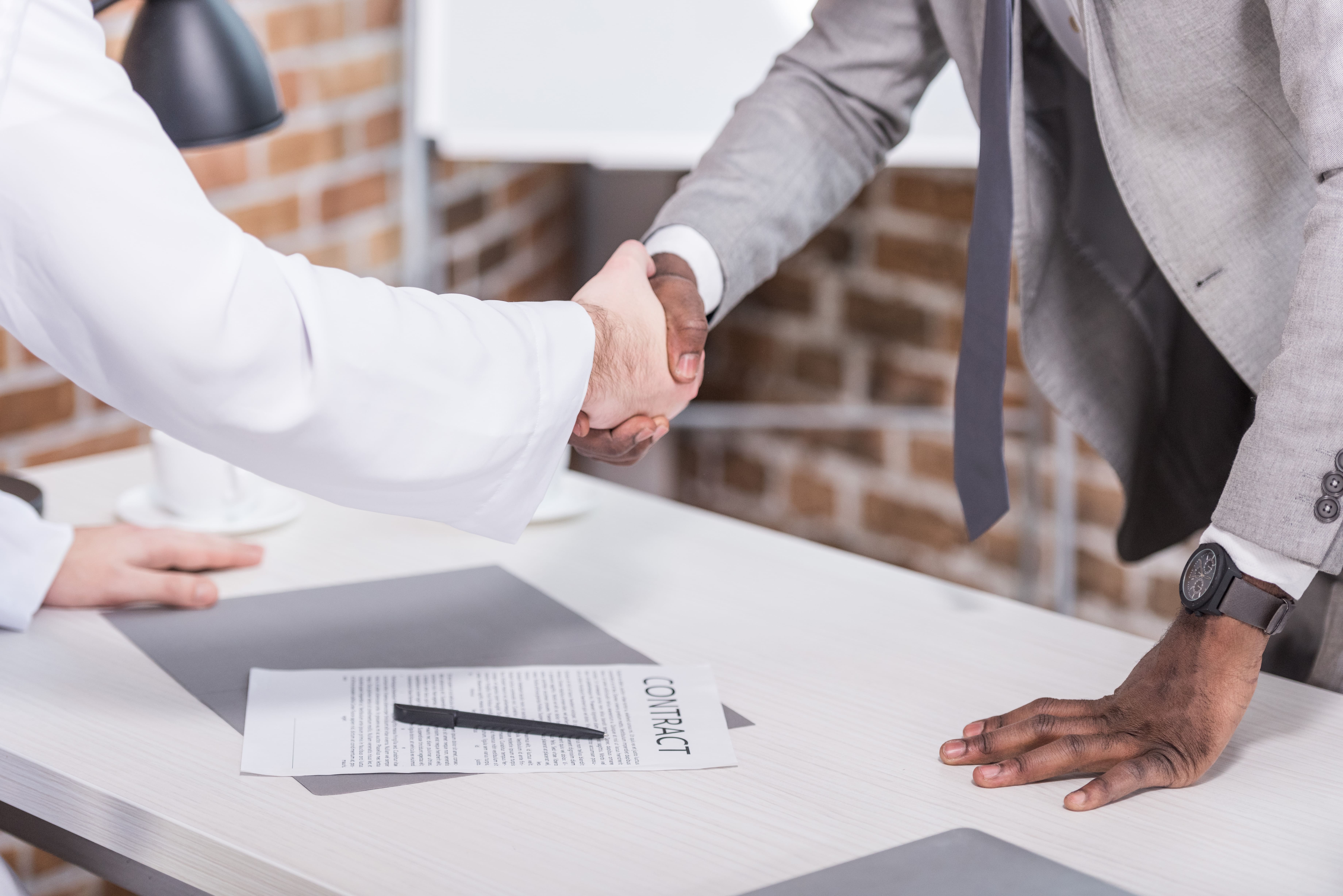 Business men shaking hands over a contract.